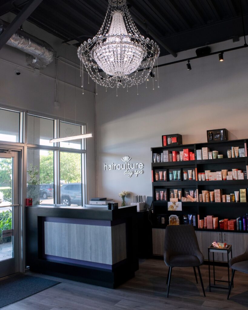 Front desk area with luxury chandelier and hair products at hair culture day spa, top rated hair salon in Pembroke Pines 