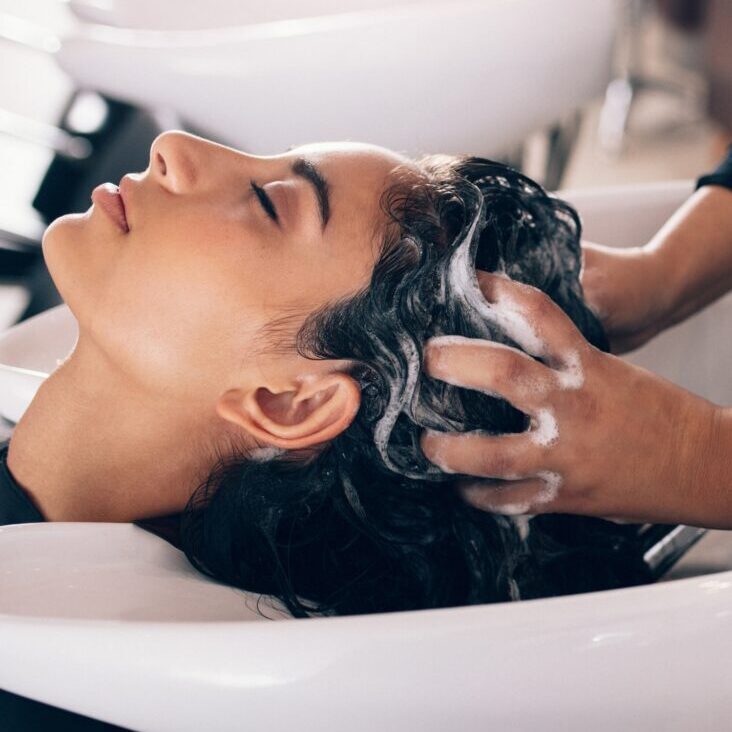 Woman getting scalp massage in shampoo bowl at beauty salon. Hair Culture Day Spa | South Florida Salon, Best Pembroke Pines, Florida Salon. Hair Care Services, scalp scanner for hair health.